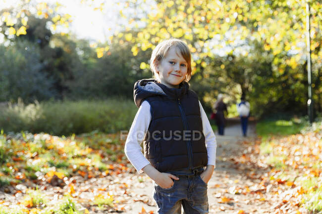 Portrait confident boy in sunny autumn park — Stock Photo