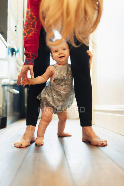 Mãe e bonito bebê filha de pé no corredor — Fotografia de Stock