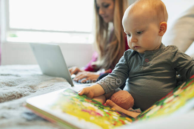 Carino curioso baby girl lettura foto libro — Foto stock