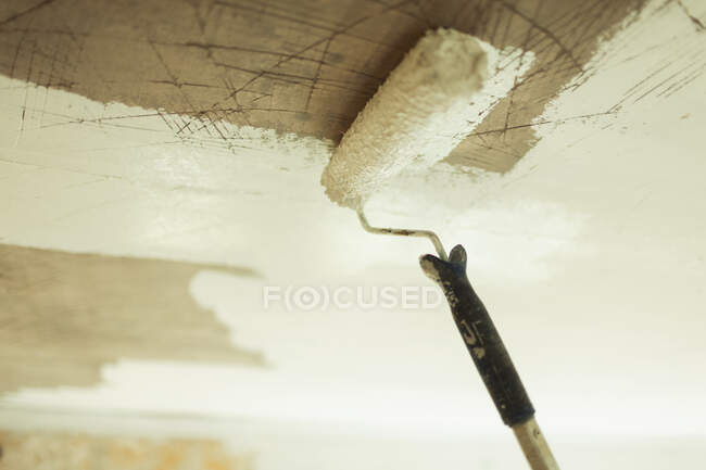 Paint roller painting ceiling white — Stock Photo