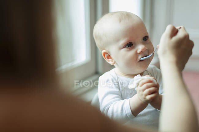 Mother feeding cute baby daughter — Stock Photo