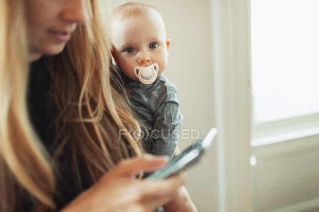 Portrait mother holding baby daughter with pacifier — Stock Photo