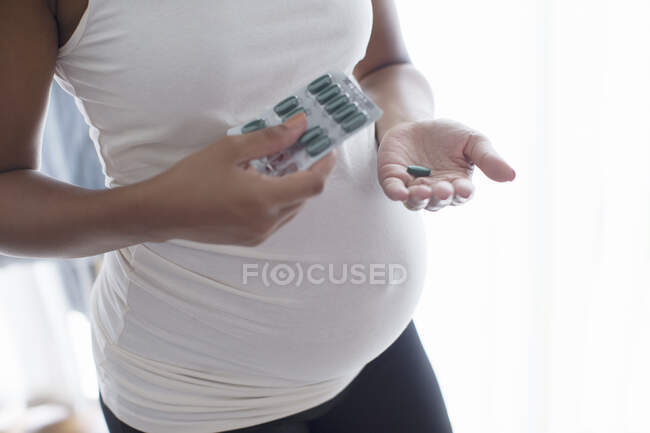 Close up donna incinta che prende vitamine — Foto stock
