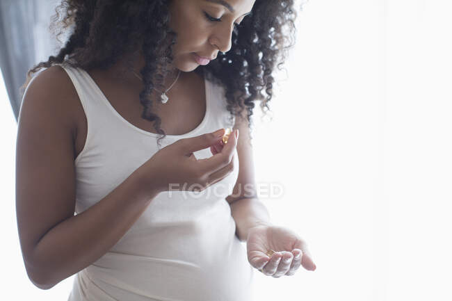 Молода вагітна жінка приймає вітаміни. — стокове фото