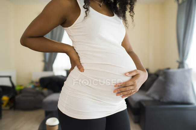 Young pregnant woman holding stomach — Stock Photo