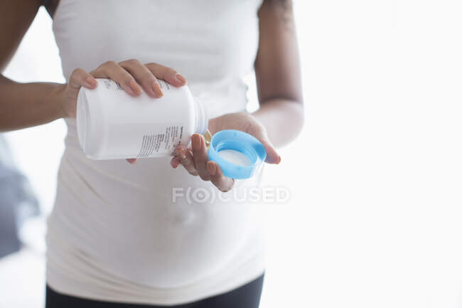 Junge schwangere Frau nimmt pränatale Vitamine — Stockfoto