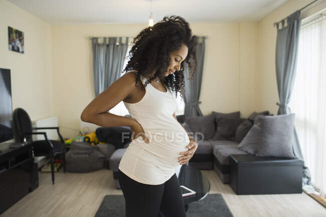 Beautiful young pregnant woman holding stomach — Stock Photo