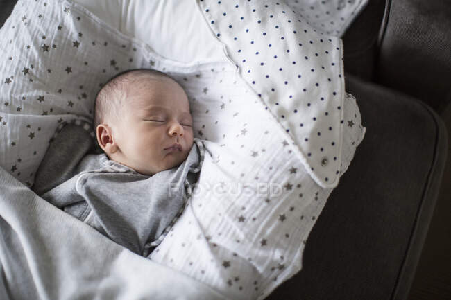 Tired newborn baby boy sleeping in bassinet — Stock Photo