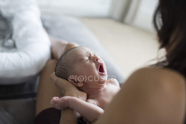Mother holding crying newborn baby son — Stock Photo