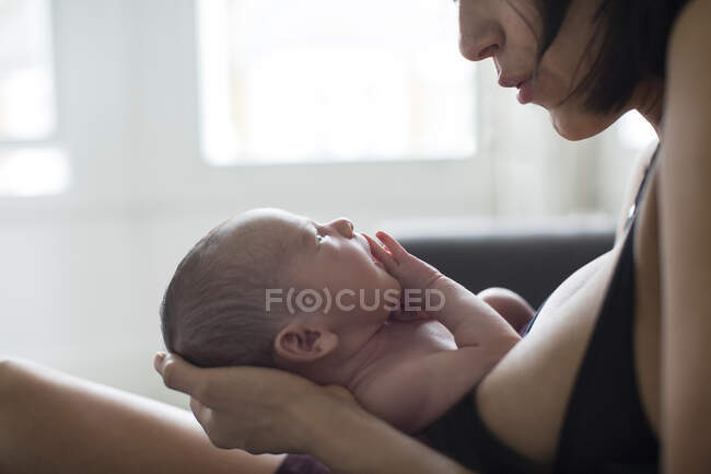Madre sosteniendo bebé recién nacido hijo - foto de stock