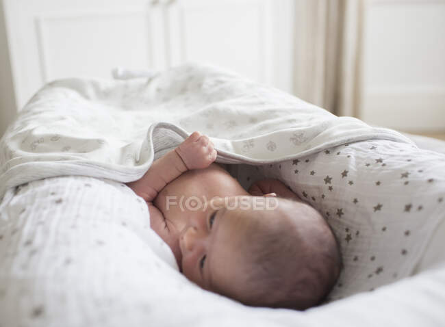 Newborn baby boy laying in bassinet — Stock Photo