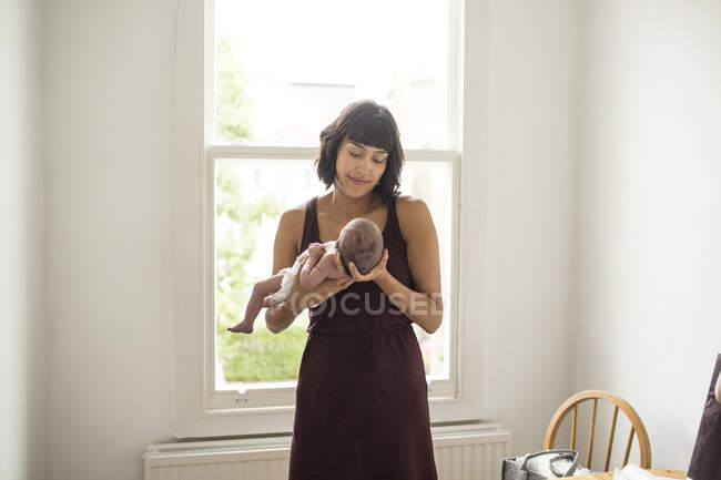 Madre sosteniendo bebé recién nacido hijo - foto de stock