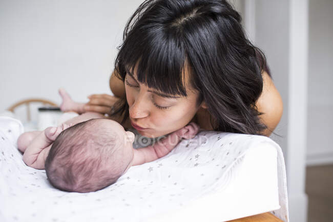 Madre besando recién nacido bebé hijo - foto de stock