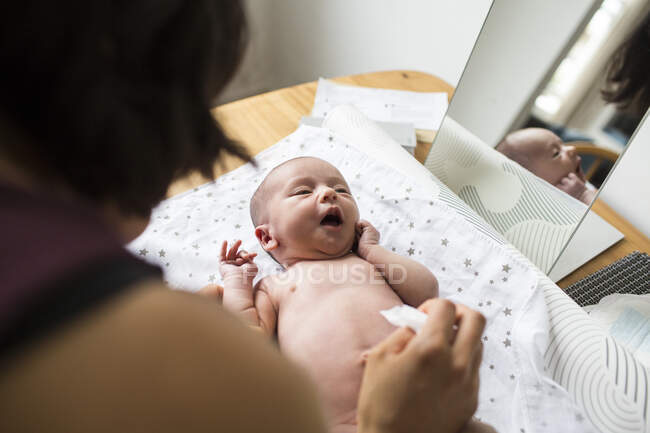 Mother changing diaper of newborn baby son — Stock Photo