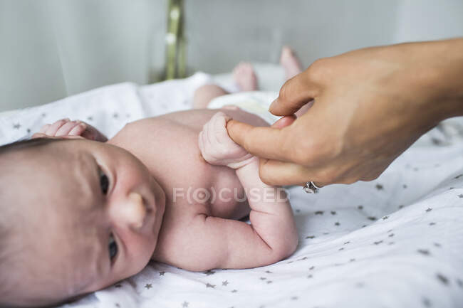 Close up mother holding hands with newborn baby son — Stock Photo