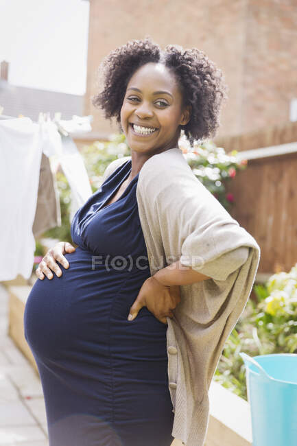 Портрет щасливої вагітної жінки в сонячному саду — стокове фото