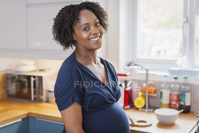 Portrait happy pregnant woman in kitchen — Stock Photo