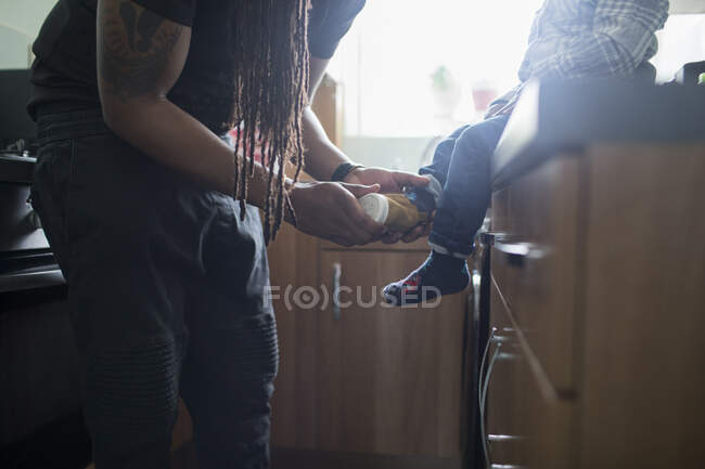 Pai colocando sapatos no filho da criança — Fotografia de Stock