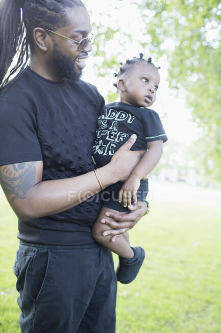 Отец держит маленького сына в парке — стоковое фото