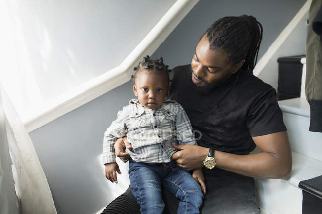 Portrait father holding toddler son on stairs — Stock Photo