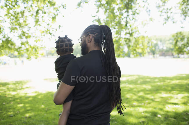 Батько, що носить маленького сина в парку — стокове фото