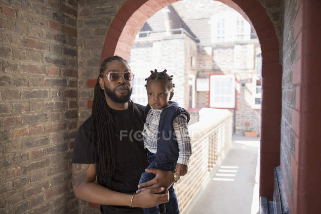 Retrato pai segurando filho criança no corredor arco caminho — Fotografia de Stock