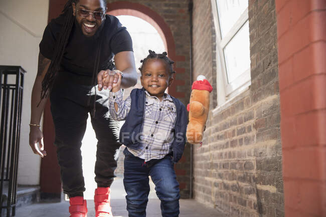 Retrato pai brincalhão e filho criança correndo no corredor — Fotografia de Stock