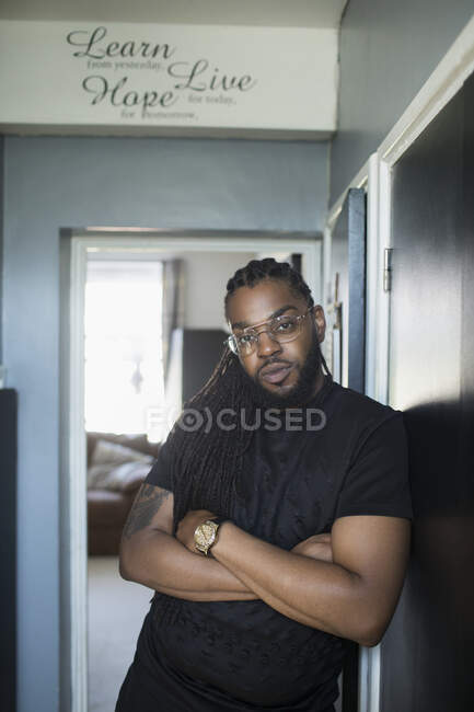 Portrait confident cool man with long braids in corridor — Stock Photo