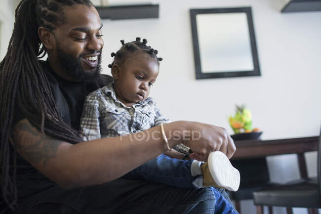 Father putting shoes on toddler son — Stock Photo
