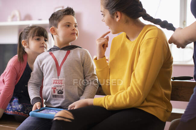 Мальчик с синдромом Дауна разговаривает с сестрой — стоковое фото