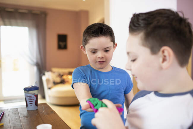 Мальчик с синдромом Дауна и брат играют — стоковое фото
