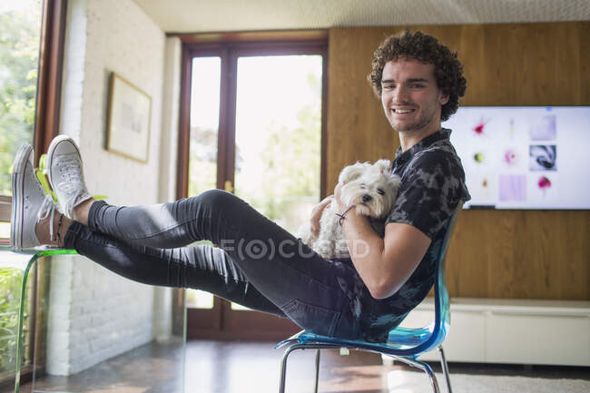 Retrato feliz joven con perro en casa oficina - foto de stock