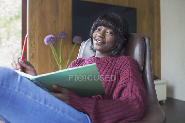Portrait happy young woman journaling — Stock Photo