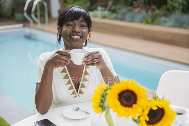 Ritratto felice giovane donna bere caffè a bordo piscina — Foto stock