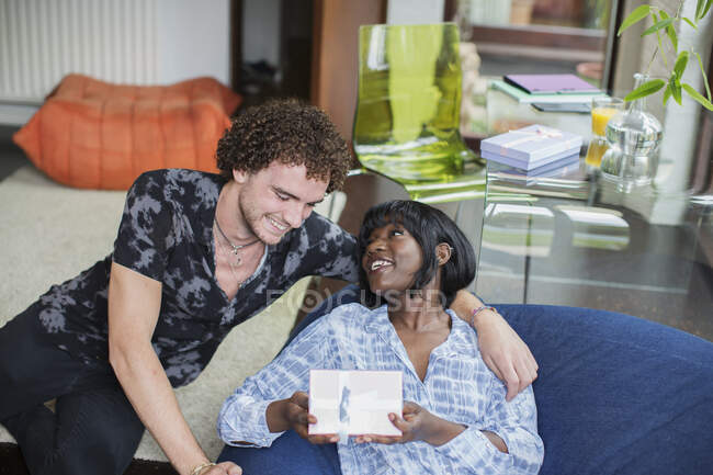 Young man giving gift to happy girlfriend — Stock Photo