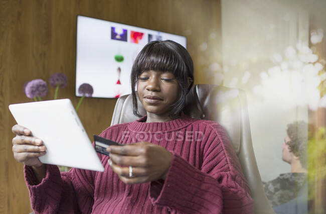 Jeune femme achats en ligne avec carte de crédit et tablette numérique — Photo de stock