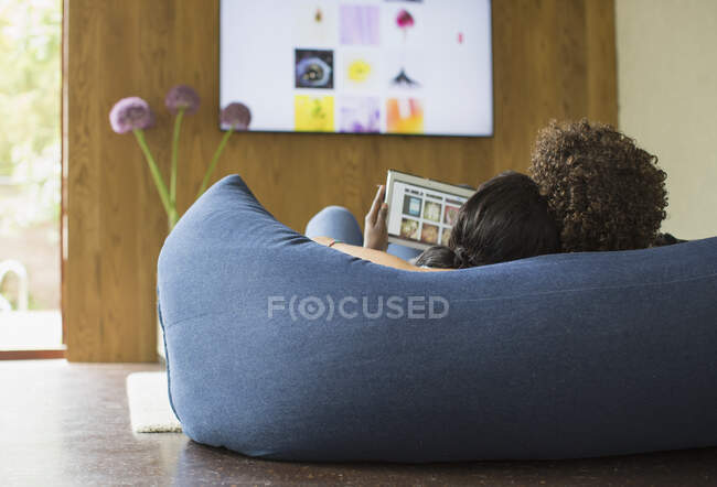 Young couple relaxing streaming photos from digital tablet to TV — Stock Photo