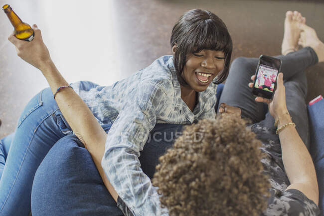 Verspieltes junges Paar jubelt und schaut Fußballspiel auf Smartphone — Stockfoto