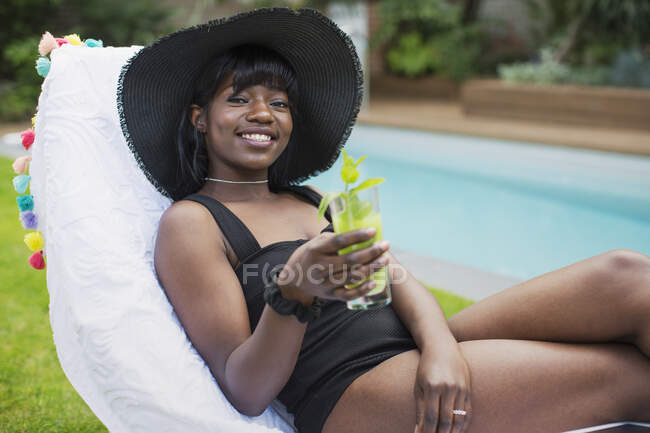 Retrato bela jovem relaxante com coquetel na beira da piscina — Fotografia de Stock