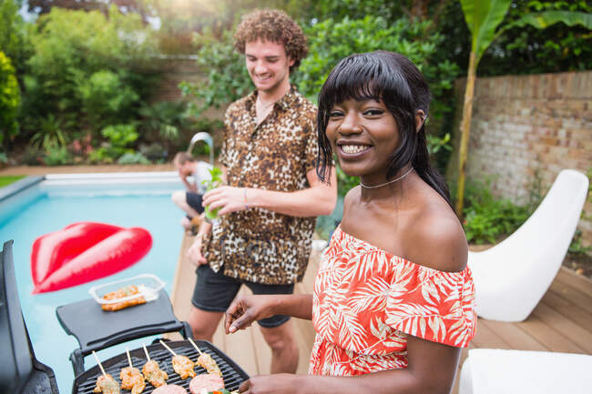 Ritratto felice giovane coppia multietnica grigliate a bordo piscina — Foto stock