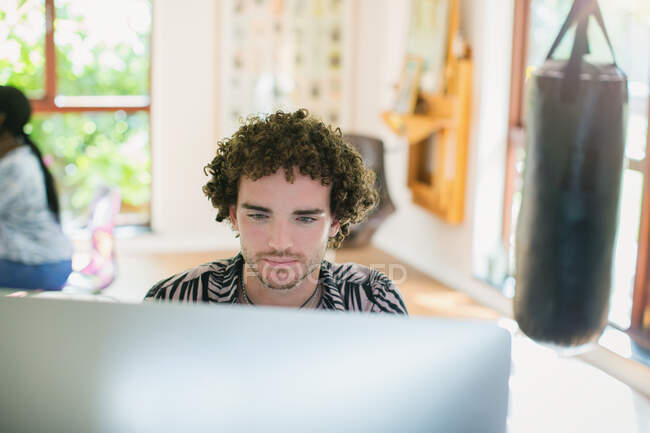 Молодой человек работает за компьютером в домашнем офисе — стоковое фото