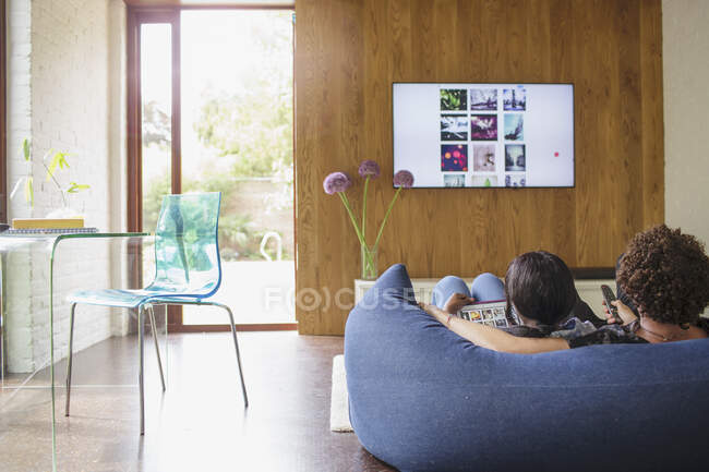 Casal jovem streaming de fotos do tablet digital para a TV — Fotografia de Stock