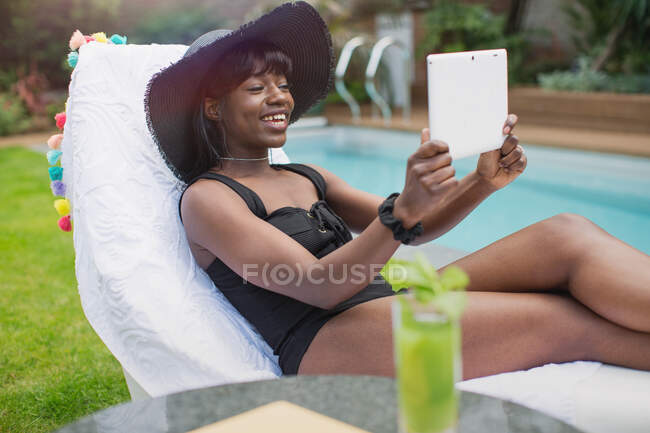 Jovem feliz vídeo conversando com tablet digital na beira da piscina — Fotografia de Stock