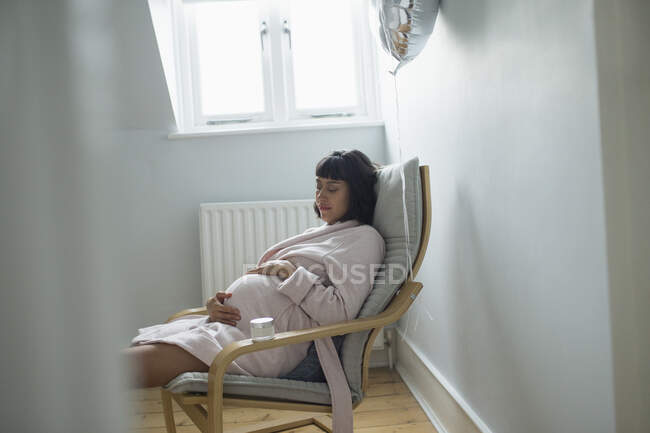 Mujer embarazada cansada durmiendo en albornoz - foto de stock
