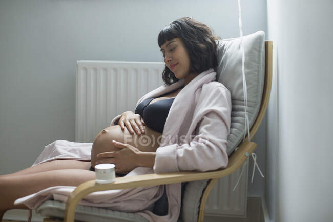Serena mulher grávida esfregando estômago — Fotografia de Stock