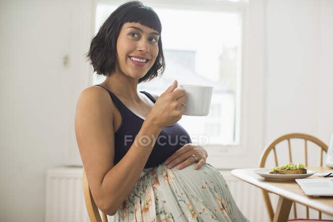 Portrait happy pregnant woman drinking tea — Stock Photo