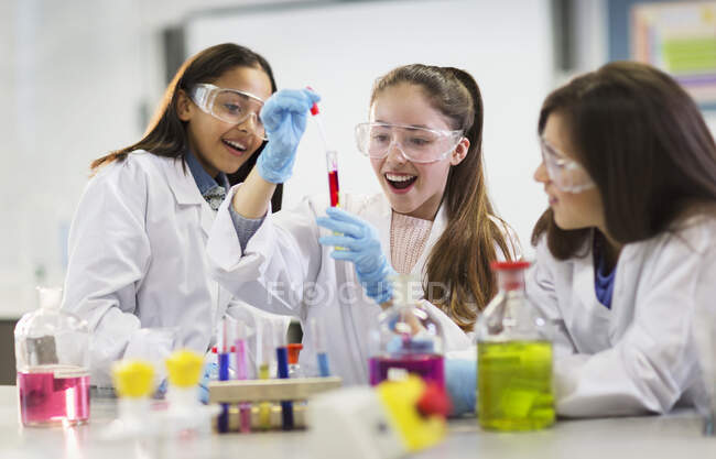 Curious girl students conducting scientific experiment in laboratory classroom — Stock Photo