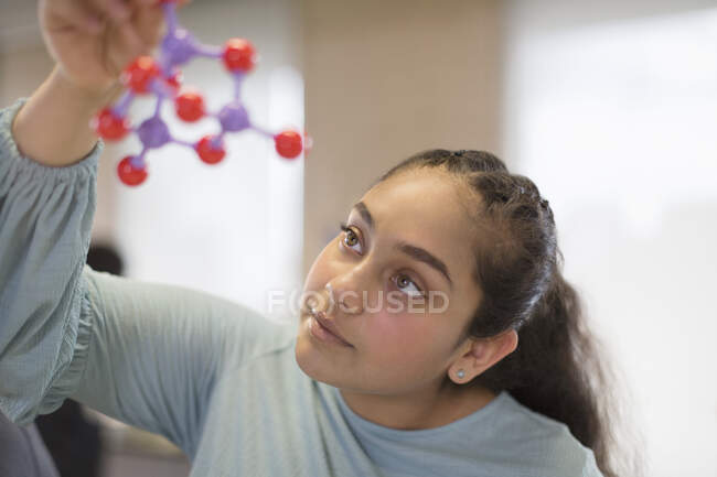 Curious girl student examining molecular structure in classroom — Stock Photo
