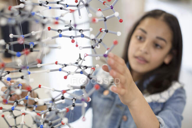 Studente ragazza esaminando e toccando struttura molecolare in aula — Foto stock