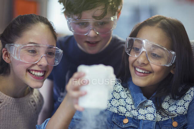 Studenti curiosi e sorridenti che guardano la reazione chimica, conducono esperimenti scientifici in classe di laboratorio — Foto stock